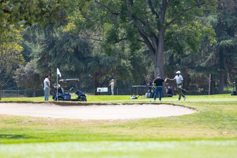a group of golfers play golf in the distance