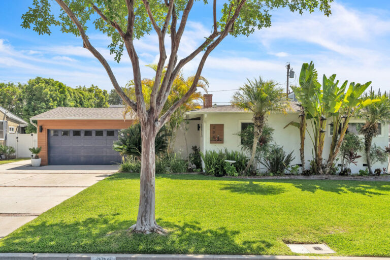 exterior of a home in Monrovia with a large tree and green front lawn