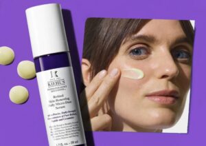 Kiehls facials with a woman putting makeup on her face on a purple background