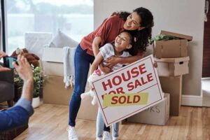 house sold signage being held by a woman and young child 