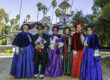 carolers in front of the Queen Anne Cottage at the LA Arboretum