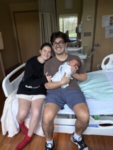 two parents holding their new born baby