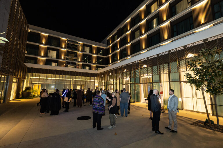 a group of people in an outdoor patio area of a hotel at night