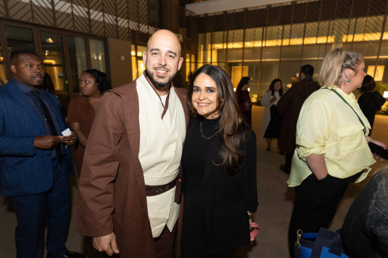 a man in a star wars costume with his arm around a woman dressed in black