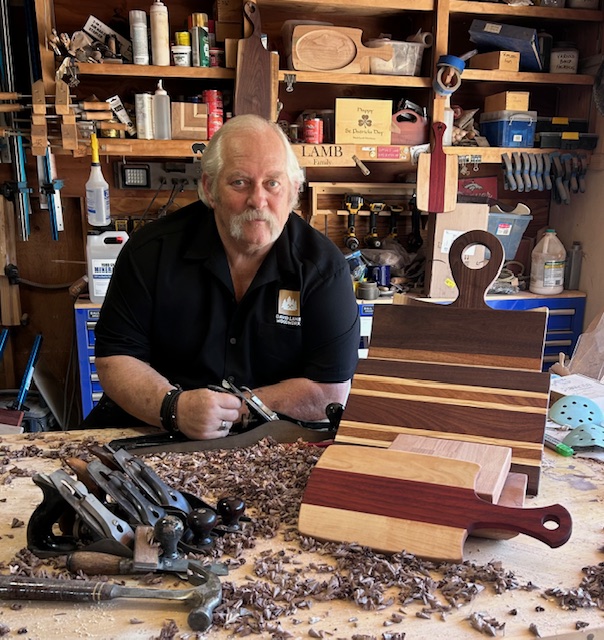 David Lamb in his workshop showing off cutting boards