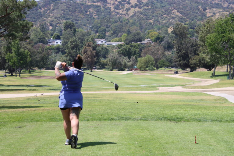 a woman in a blue dress playing on a golf course