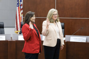 two women hold up their hands to be sworn in for the Arcadia Unified School District board of education