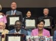 Judy Chu seated with a group of people all holding up awards