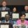 Judy Chu seated with a group of people all holding up awards