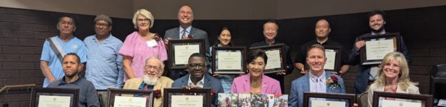 Judy Chu with award winners Judy Chu seated with a group of people all holding up awards