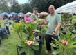 two people posing with a plumeria tree