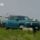 a sheep running past a Rivian truck