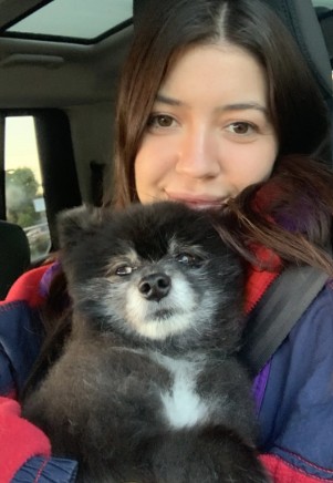 a woman with a cute, sugar-faced black dog on her lap