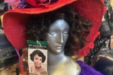 a mannequin head wearing a black wig and red hat