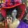 a mannequin head wearing a black wig and red hat