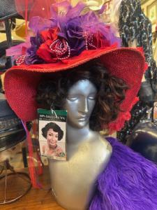 a mannequin head wearing a black wig and red hat