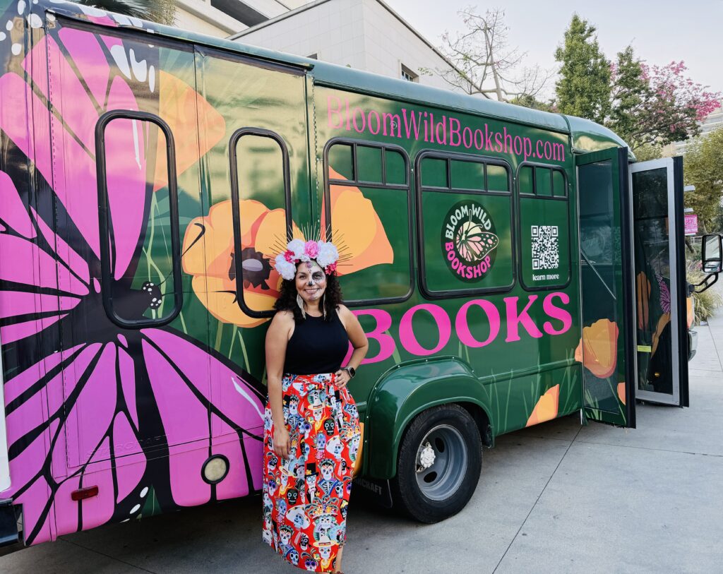 a woman in a colorful outfit standing in front of a painted bus