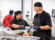 two men in a food kitchen preparing food