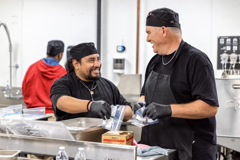 two men in a food kitchen preparing food